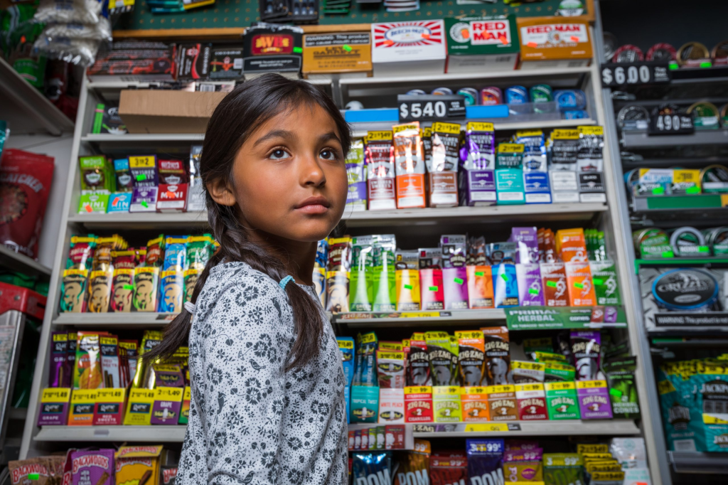 girl standing in front of tobacco display